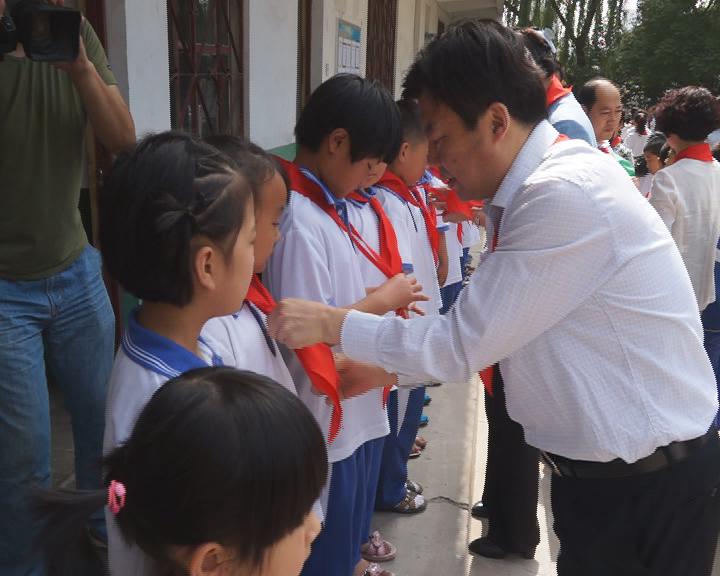 毛华铭书记给学生戴红领巾.jpg